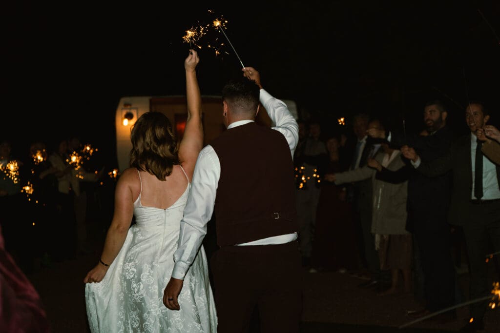 A newlywed couple doing a sparkler exit at the end of their micro wedding celebration at an Airbnb style venue in Woodland Park